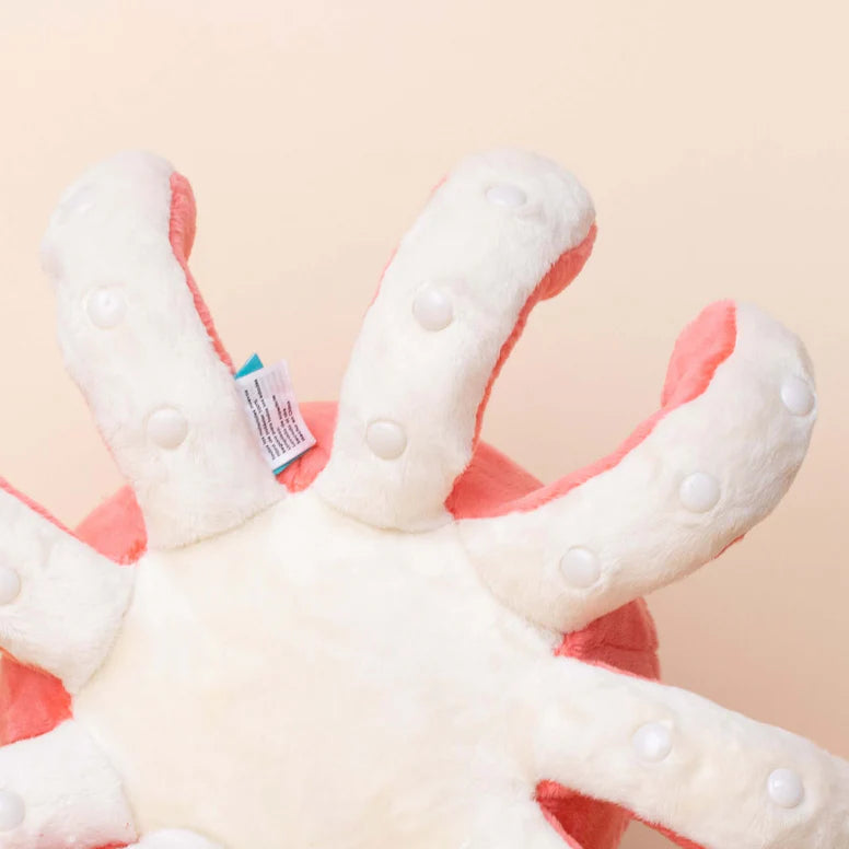 Close up of the bottom of a plush octopus toy. The bottom is white, and the bottom of the tentacles is white with shiny round dots for suckers.