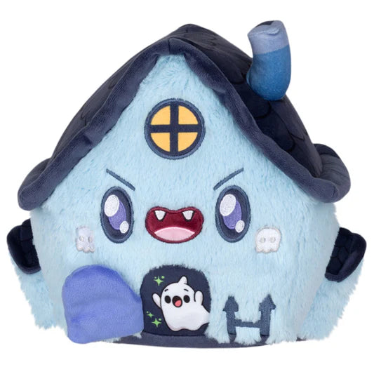 Plush toy shaped like a haunted house with a grinning face, with ghost characters and embroidered details on a white background. The house has a door that is open showing a ghost inside.