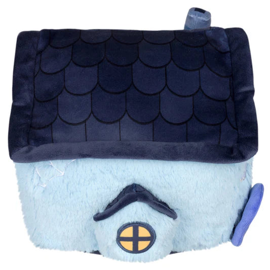 Side view of a plush toy haunted house with a blue body and dark roof on a white background. The house has an embroidered window.