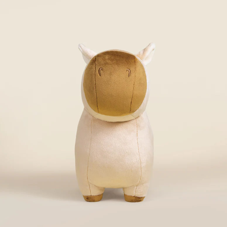 Plush toy capybara with a brown face and tan body on a beige background