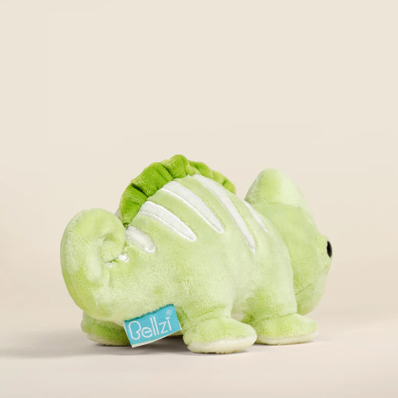 Green plush toy chameleon on a beige background.