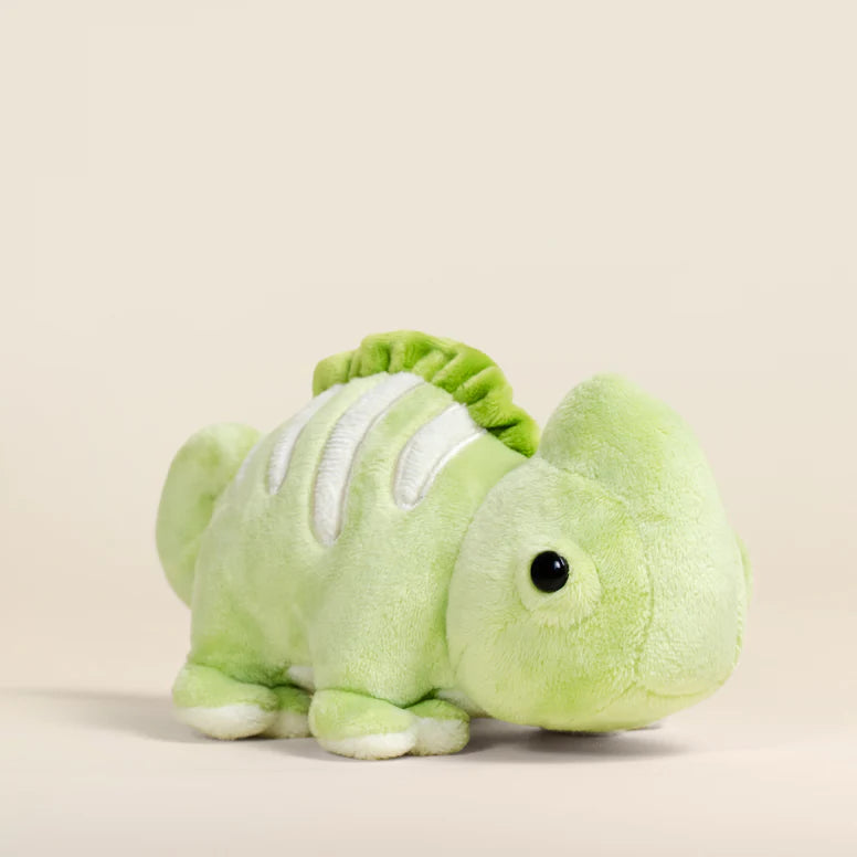 Green plush toy chameleon on a beige background.