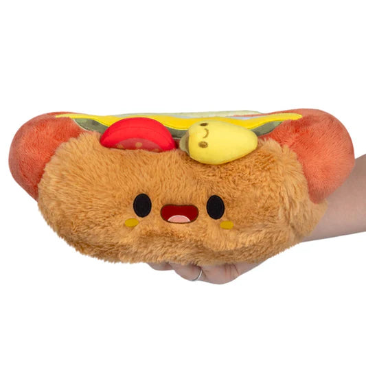 Plush toy shaped like a hot dog with a face on a white background
