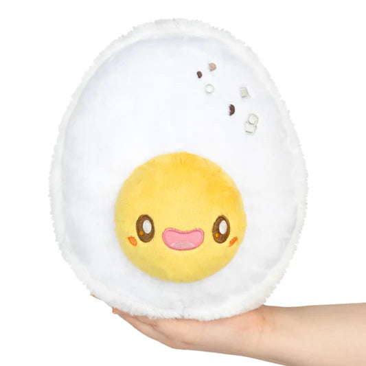 Plush toy of a cartoonish boiled egg with a face held in a hand on a white background