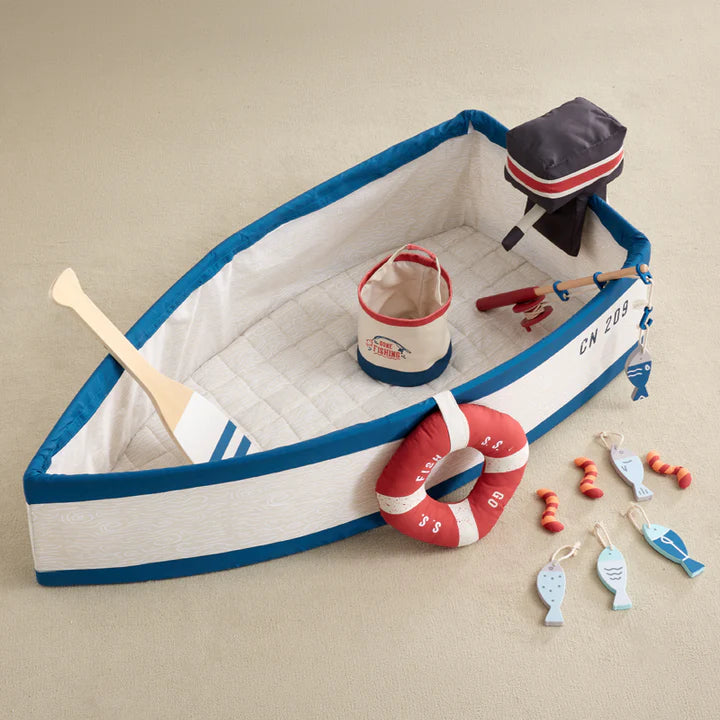 Toy boat with accessories on a beige background
