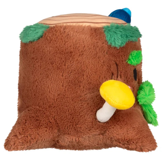 Side view of a plush toy resembling a tree with a yellow mushroom on a white background.